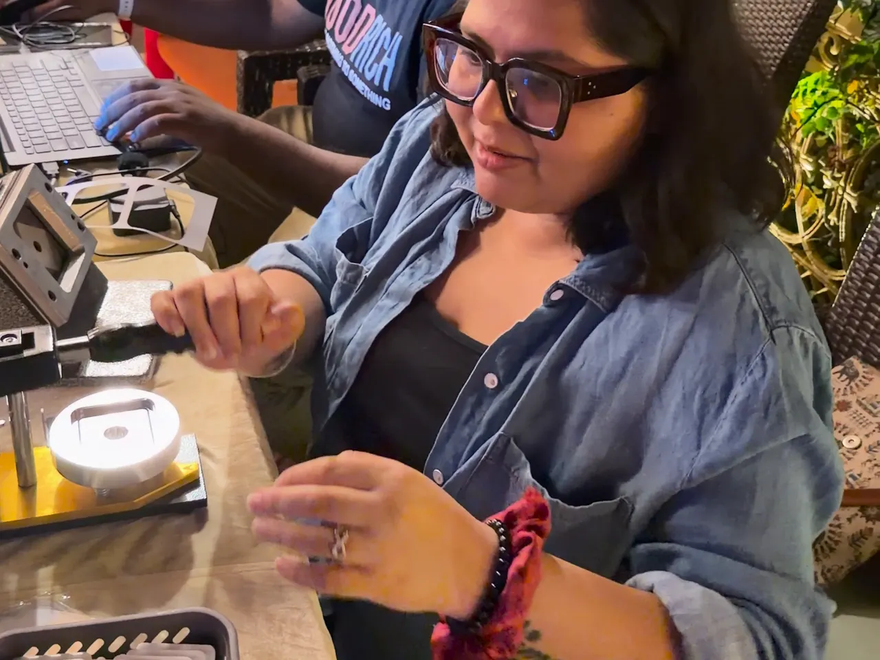 A crew member assembling a photo magnet at the stall counter