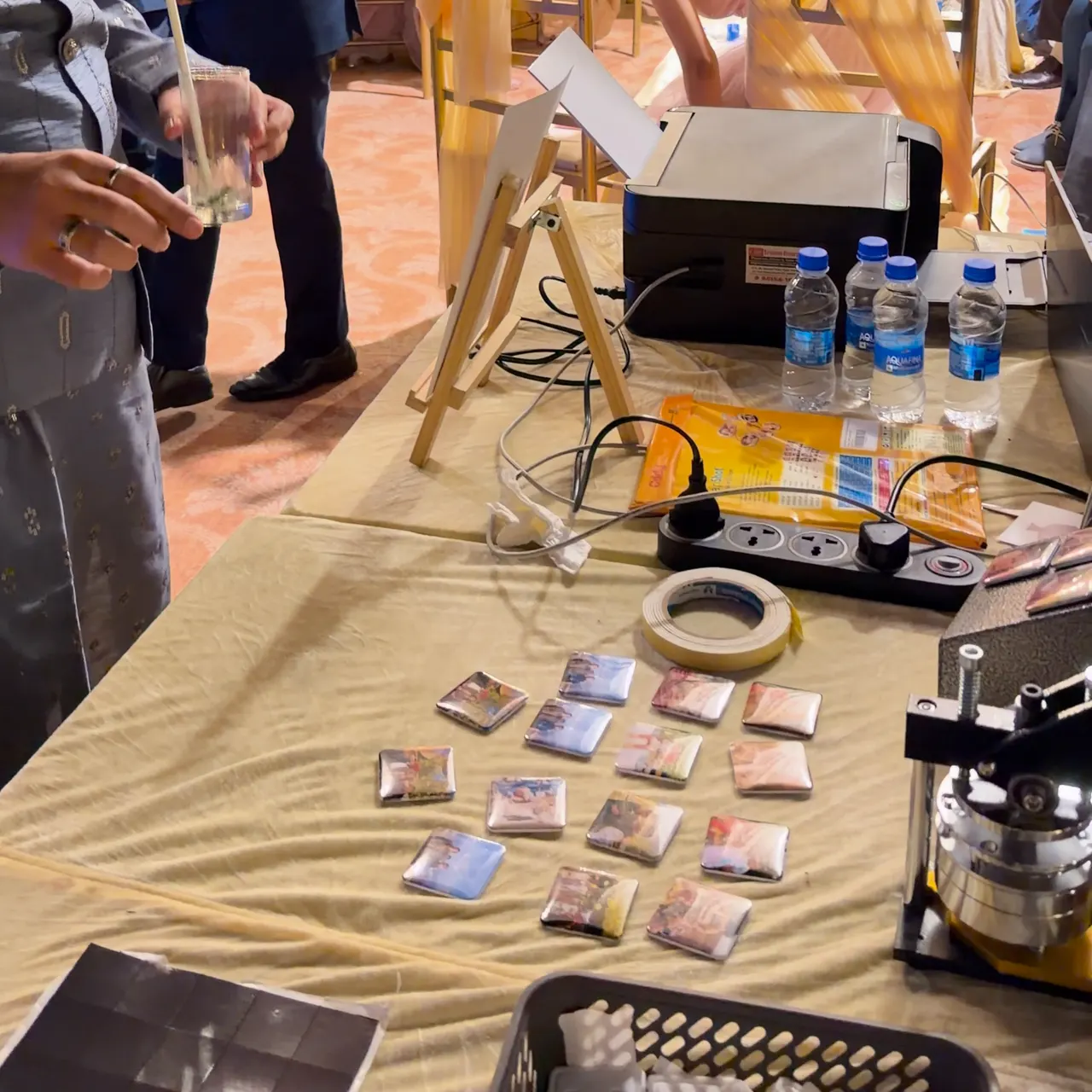 Photo magnets laid out across the stall table as guests stand nearby