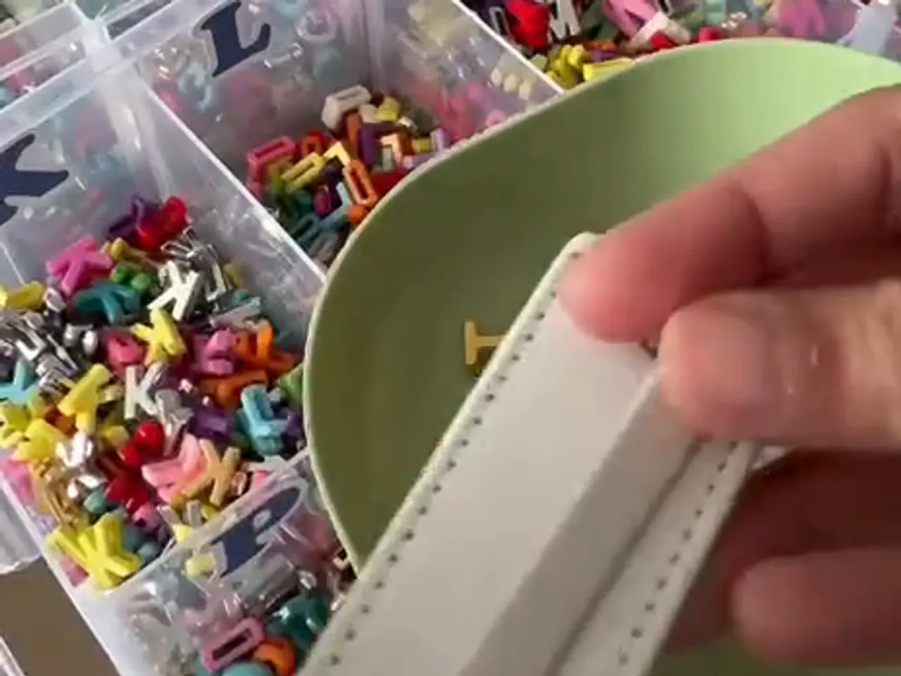 A tray of alphabet beads and a keychain strap being put together at the stall